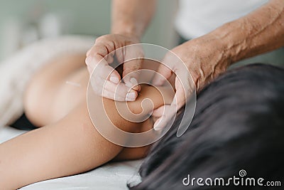 acupuncturist pinches patient& x27;s neck to insert acupuncture needle Stock Photo