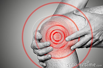 Acute pain in a knee joint, close-up. Monochrome image, on a white background. Pain area of red color Stock Photo