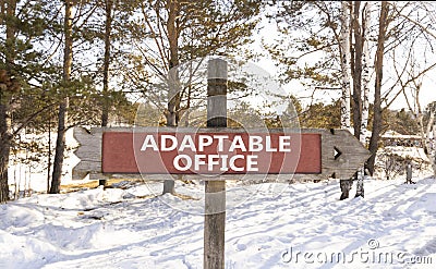 Adaptable office symbol. Concept words Adaptable office on beautiful wooden road sign. Beautiful winter forest snow tree Stock Photo