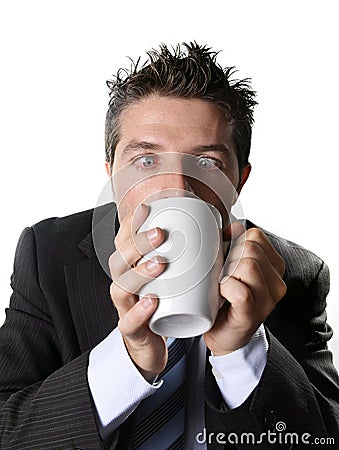 Addict business man in suit and tie drinking cup of coffee anxious and crazy in caffeine addiction Stock Photo