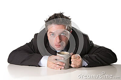 Addict businessman in suit and tie holding cup of coffee as maniac in caffeine addiction Stock Photo