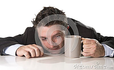 Addict businessman in suit and tie holding cup of coffee as maniac in caffeine addiction Stock Photo