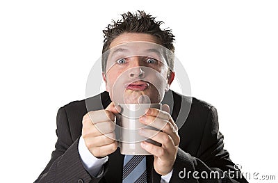 Addict businessman in suit and tie holding cup of coffee as maniac in caffeine addiction Stock Photo