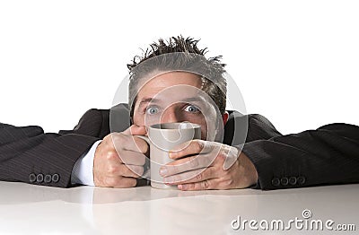 Addict businessman in suit and tie holding cup of coffee as maniac in caffeine addiction Stock Photo