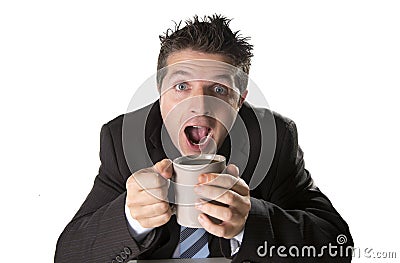 Addict businessman in suit and tie holding cup of coffee as maniac in caffeine addiction Stock Photo