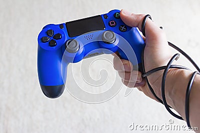 Addiction to video games concept, blue game pad with wrapped hand Stock Photo