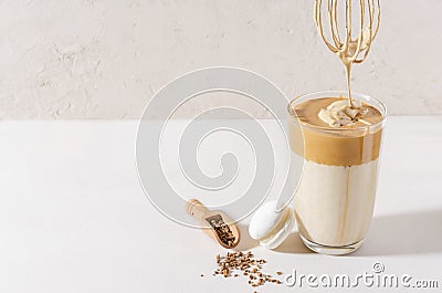 Adding foam in Dalgon coffee in a glass beaker on a light background Stock Photo