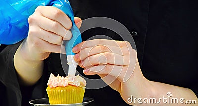 Adding frosting to a cupcake Stock Photo