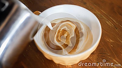 Adding milk foam to coffee to make a cup of cappuccino Stock Photo