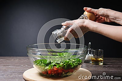 Adding pepper to salad Stock Photo