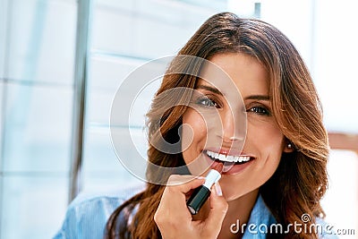 Adding some colour to my lips. a beautiful young woman applying lipstick at home. Stock Photo