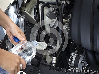 Adding water to the car radiator should open the hood once a week to observe the water in the radiator. And reserve water tank In Stock Photo