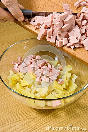 Addition of boiled wurst in salad Stock Photo