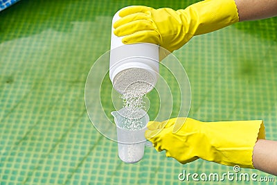 Addition of chlorine powder for the pool to remove algae and disinfect water. inflatable swimming pool care concept. Stock Photo