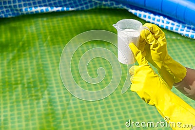 Addition of chlorine powder for the pool to remove algae and disinfect water. inflatable swimming pool care concept. Stock Photo