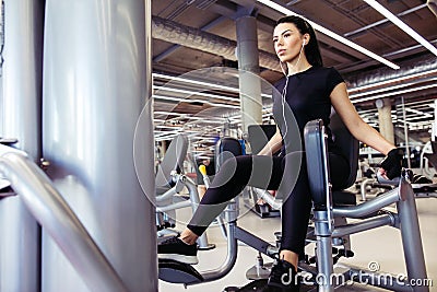 Adduction or abductor machine. girl exercising her legs in gym Stock Photo
