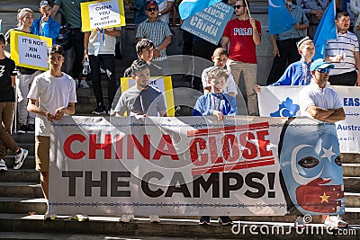 Young Uyghur-Australian demonstrators hold banner at the front line Editorial Stock Photo