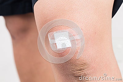 Adhesive plaster bandage over bruise on the knee Stock Photo