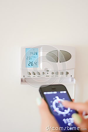 Adjust temperature in home interior with smartphone Stock Photo