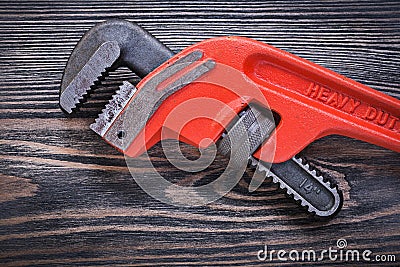 Adjustable monkey wrench on wooden board directly above plumbing Stock Photo