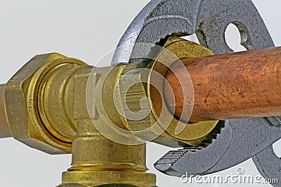 Plumber`s adjustable wrench tightening up copper pipework Stock Photo