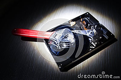 Adjustable wrench turn off a hard disk. On a dark background. Computer repair concept Stock Photo