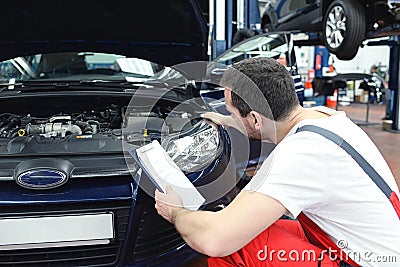 adjusting the headlights on the car by mechanics in a garage Stock Photo