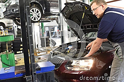 adjusting the headlights on the car by mechanics in a garage Stock Photo