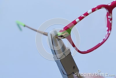 Adjusting inclination on patchy red and white children eyeglass frame with conical nylon jaws inclination pliers. Stock Photo