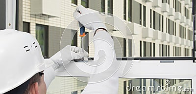 Adjusting the open window for the correct operation of the lock, by the builder, close-up Stock Photo