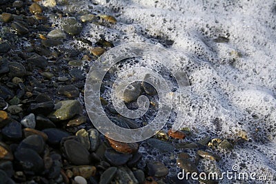 Adler, Sochi, Krasnodar Territory, Russia - 08.04.2015. A wave with foam washes a large pebble on the Black Sea coast Stock Photo