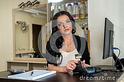 Administrator in beauty salon making payment with terminal Stock Photo