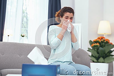 Adolescent lady with influenza blowing her nose Stock Photo