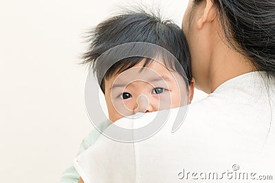 Adorable asian baby sick and unhappy on mom shoulder. Stock Photo