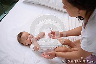 Adorable baby boy laughing and smiling looking at his mom cuddling him. Babyhood and infancy. Maternity and baby care Stock Photo