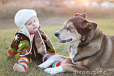 Adorable Baby Bundled up Outside with Pet Dog Stock Photo