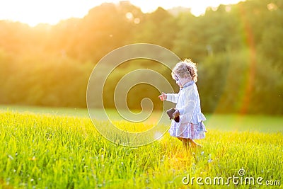 Adorable baby girl in autumn field at sunset Stock Photo