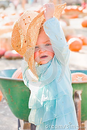 Adorable Baby Girl with Cowboy Hat in a Country Rustic Setting at the Pumpkin Patch Stock Photo