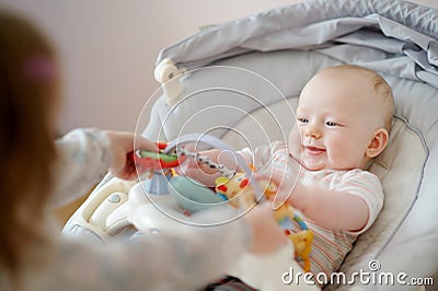 Adorable baby girl playing with older sister Stock Photo