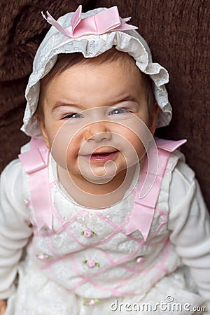 Adorable Baby Girl Smiling With a Scrunched Face She is Wearing Stock Photo