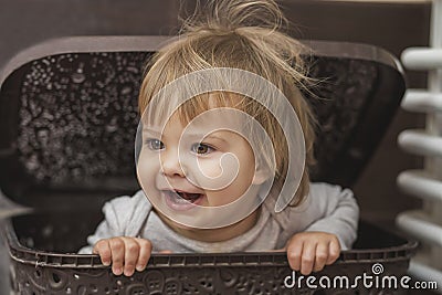 Adorable baby hiding in a laundry basket Stock Photo