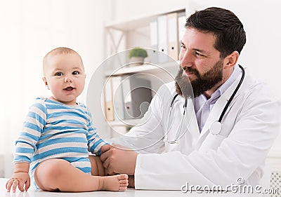 Adorable baby sitting with doctor at clinic Stock Photo