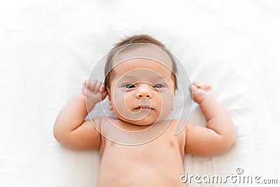 Adorable beautiful newborn baby cradled in its mothers hands looking up with a look of wonderment Stock Photo