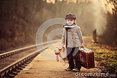 Adorable boy on a railway station, waiting for the train Stock Photo