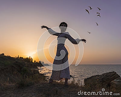 Adorable Caucasian Brunette girl in Light Dress Enjoying at the Seacoast at Sunrise time. Stock Photo