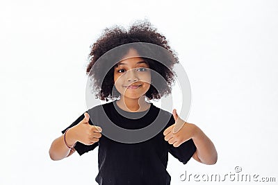 Adorable and cheerful African American kid with afro hairstyle giving thumbs up Stock Photo