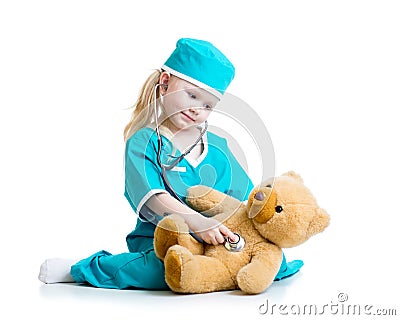 Adorable child with clothes of doctor examining teddy bear toy Stock Photo