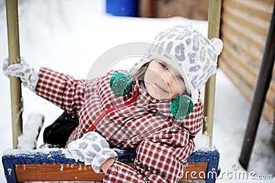 Adorable child girl enjoys seesaw in winter Stock Photo