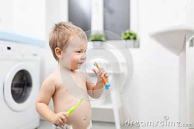 Adorable child learing how to brush his teeth Stock Photo