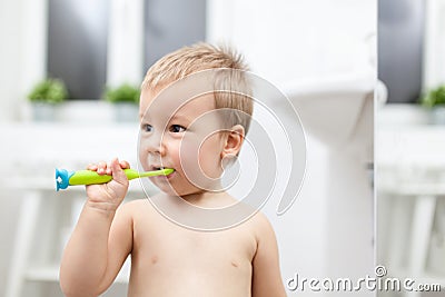 Adorable child learing how to brush his teeth Stock Photo